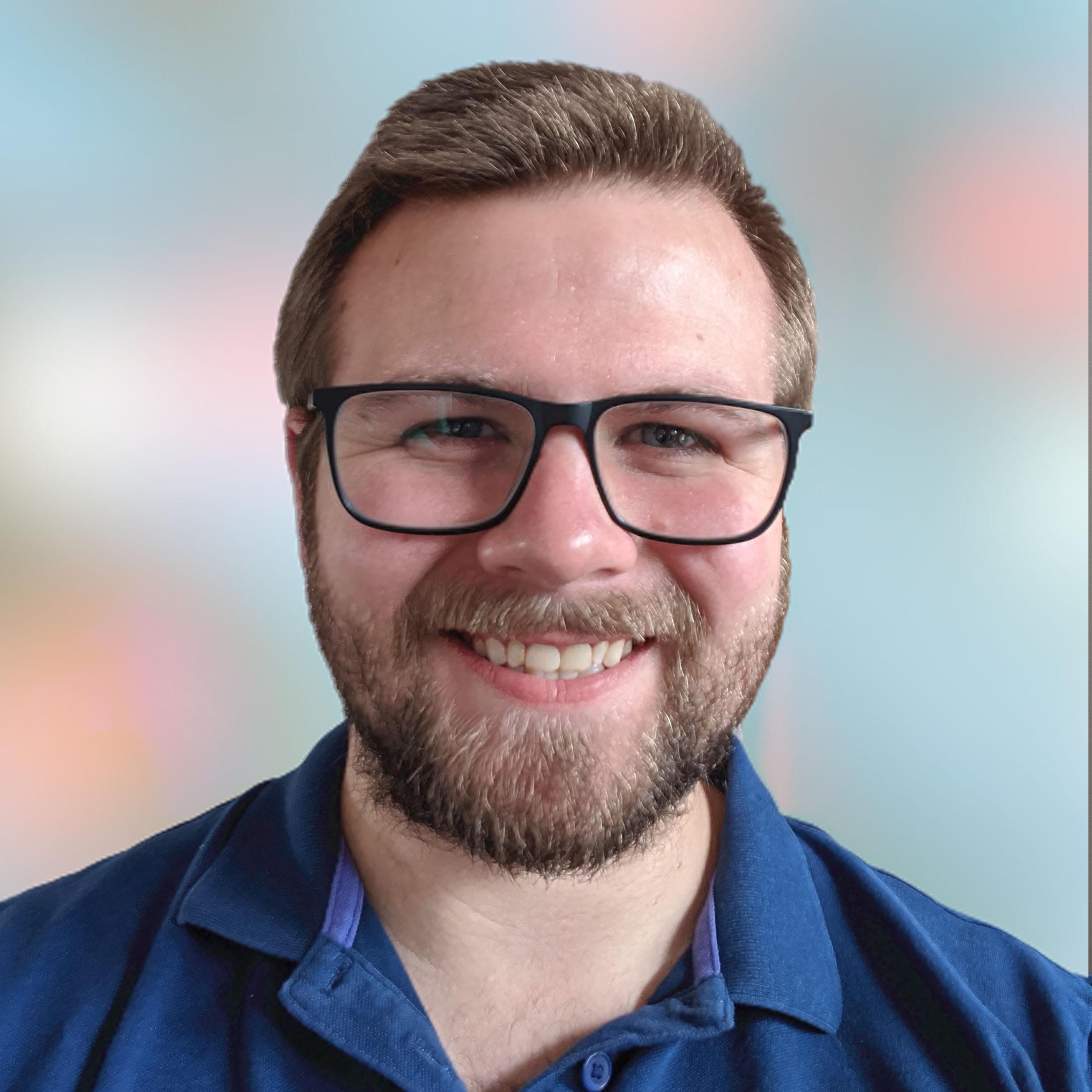 Avatar of Tim smiling in a blue polo shirt against a blurred bubble background